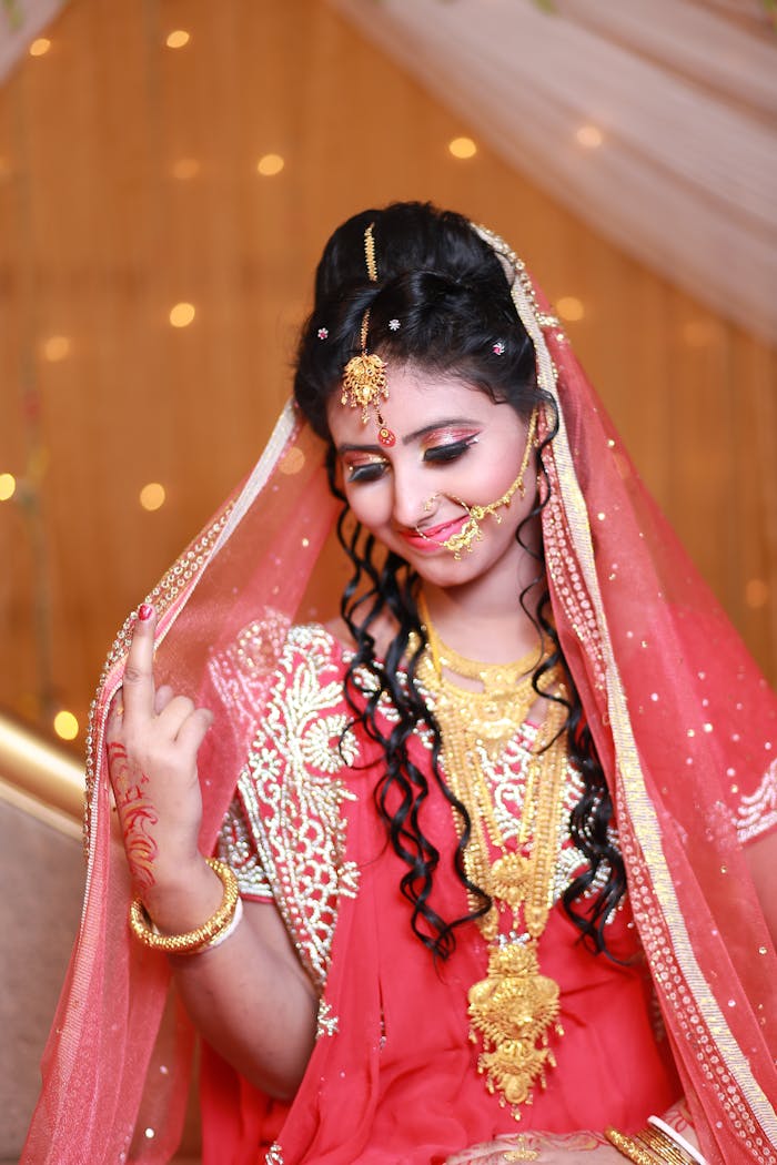 Beautiful Indian bride in traditional red saree and gold jewelry, exuding grace and elegance.